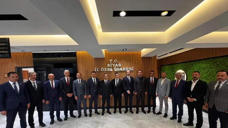 T.C. Sivas İl Özel İdaresi yazısı önünde takım elbiseli bir grup erkek yan yana duruyor.