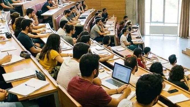 Bir derslikte oturan öğrenciler, ders dinliyorlar ve not alıyorlar.