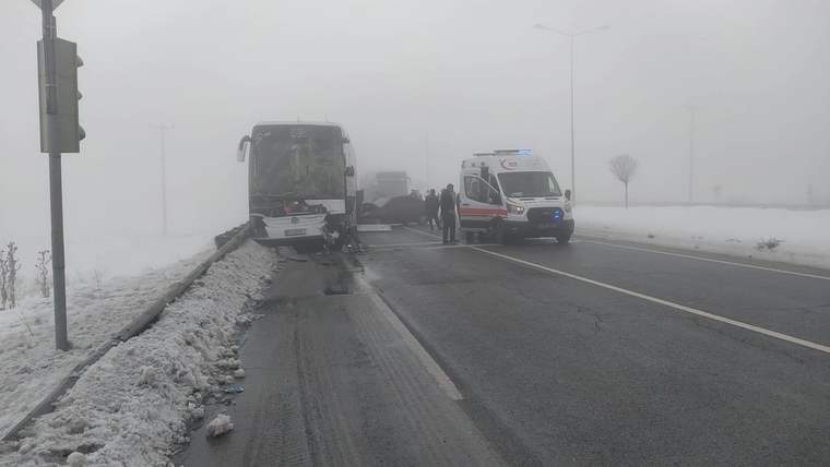 Karla kaplı yolda, bir yolcu otobüsü ve ambulans, kaza sonrası duruyor.