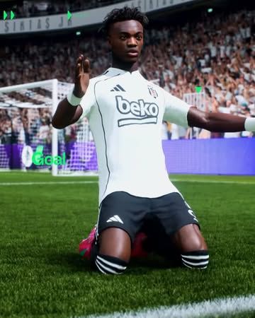 Beşiktaş armalı beyaz forma giyen bir futbolcu, yeşil sahada dizleri üzerinde kollarını açıyor.