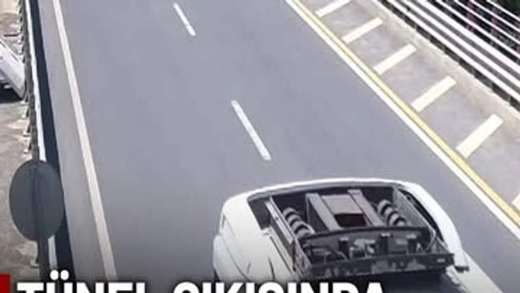 Bölünmüş yolda, üst kısmı ve iç aksamı görünen beyaz bir minibüs; yanında şerit çizgileri ve korkuluk bulunuyor.