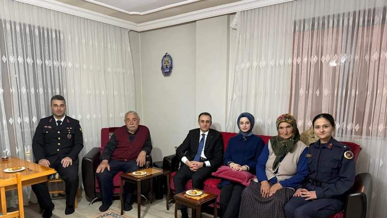 Bir odada koltuk ve sandalyelerde oturan üçü üniformalı, altı kişilik bir grup görülüyor.