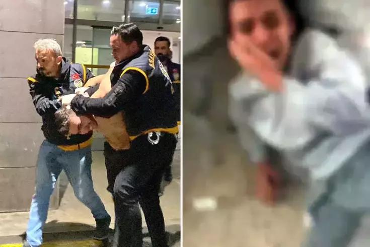 İki güvenlik görevlisi, bir kişiyi zorla tutarak bir alandan çıkarıyor.