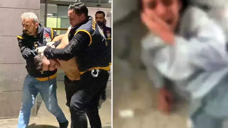 İki güvenlik görevlisi, bir kişiyi zorla tutarak bir alandan çıkarıyor.