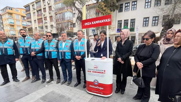 Açık alanda, üzerinde “İMZA KAMPANYASI” yazan pano önünde bir grup kişi ve imza standı bulunuyor.