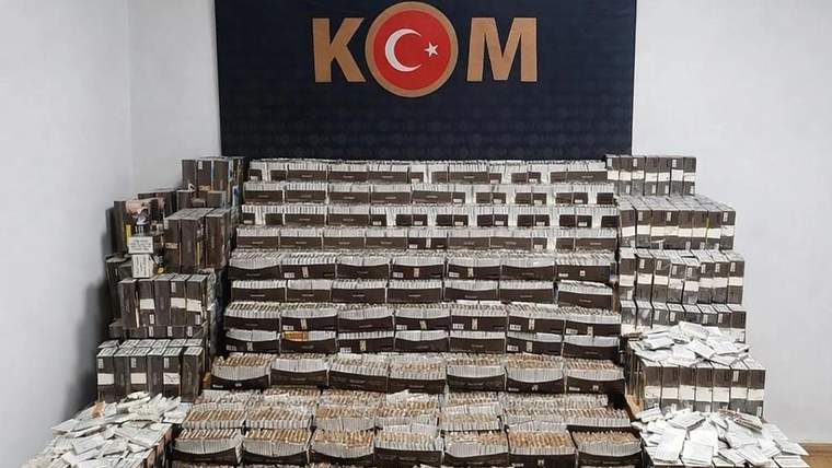 Bir odada, üst üste dizilmiş kutular içinde çok sayıda makaron ve tütün paketleri yer alıyor.