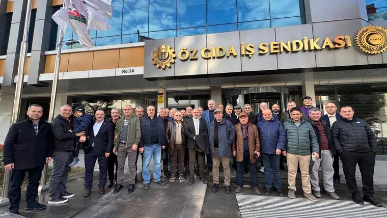 Öz Gıda-İş Sendikası binasının önünde, farklı yaşlardan yaklaşık 25 kişi toplu halde duruyor.