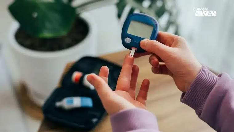 Bir kişi, parmağındaki kan damlasını mavi bir glikoz ölçüm cihazıyla kontrol ediyor.