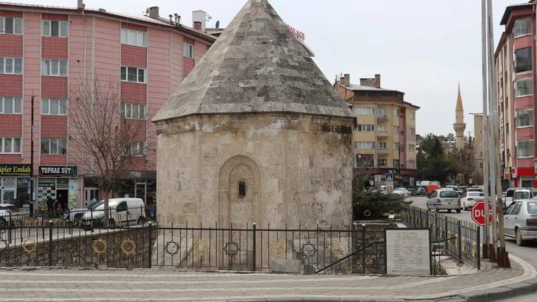Ahi Emir Ahmed Türbesi, etrafı demir parmaklıklarla çevrili, koni şeklinde çatılı bir yapı.