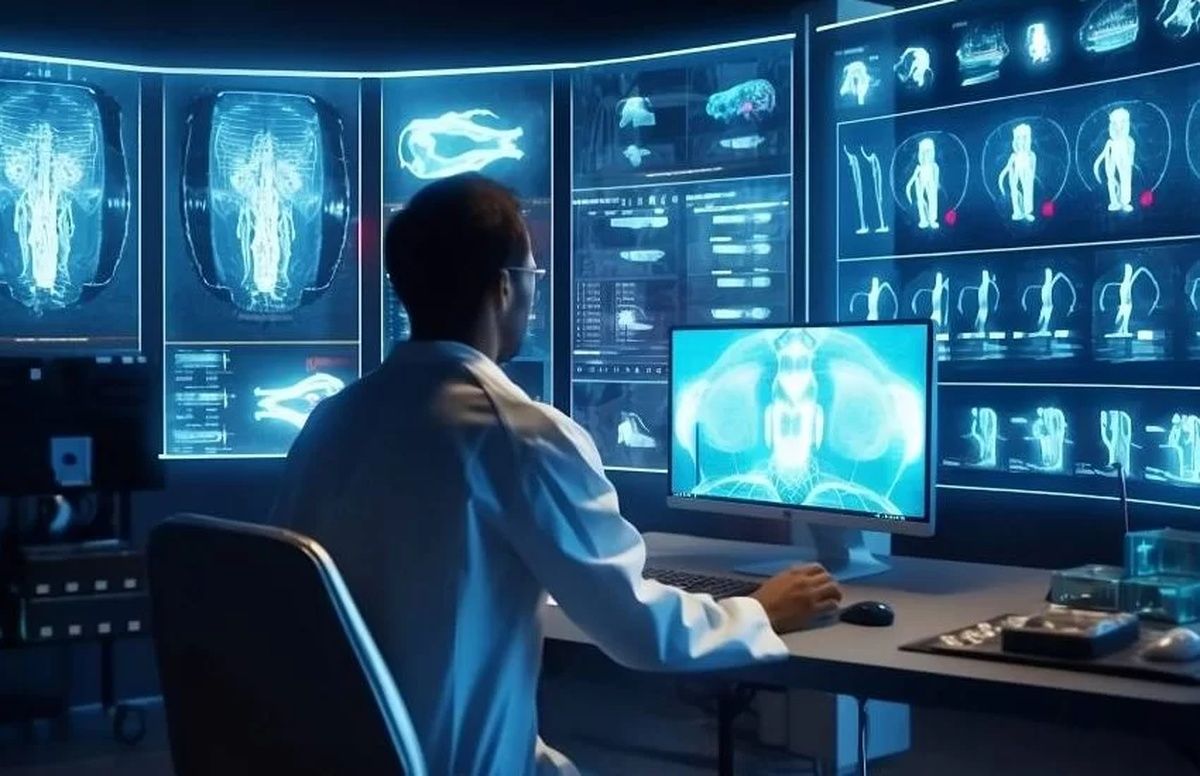 Bir kişi, tıbbi görüntü ve insan anatomisi çizimleri bulunan ekranların önünde bilgisayar kullanıyor.