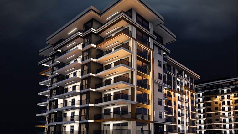 Gece görüntüsünde, modern mimariye sahip çok katlı bir apartman binası yer alıyor.