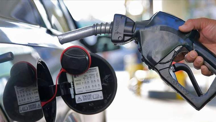 Bir kişi, bir aracın yakıt deposuna motorin pompasını yerleştiriyor.