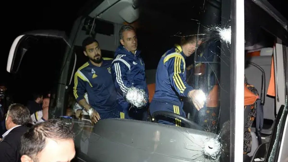 Gece çekiminde, camı çatlamış bir otobüsün içinde eşofmanlı birkaç kişi görülüyor.