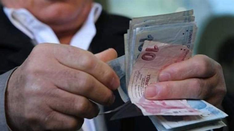 Bir kişinin elleri, cüzdanından farklı değerde Türk lirası banknotlarını çıkarırken görülüyor.