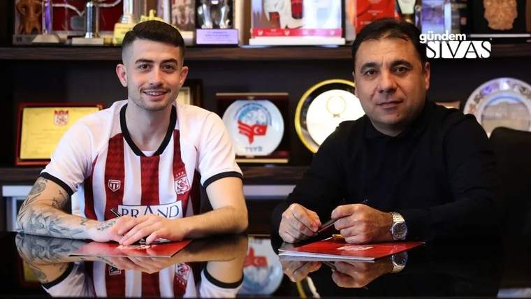 Sivasspor forması giymiş bir oyuncu ve masada oturan bir yönetici, sözleşme imzalıyorlar.