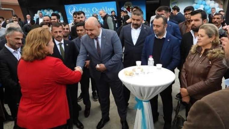 Bir grup insan, açılış etkinliğinde birbirleriyle selamlaşıyor.