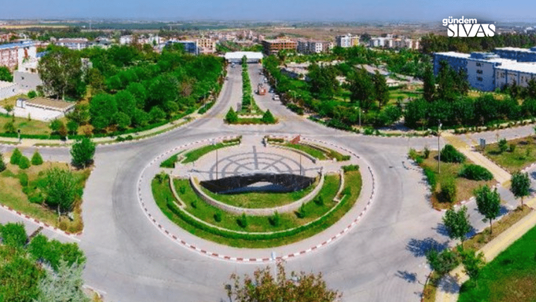 Bir kavşak, ortasında çiçekler ve ağaçlarla süslenmiş bir alan var.