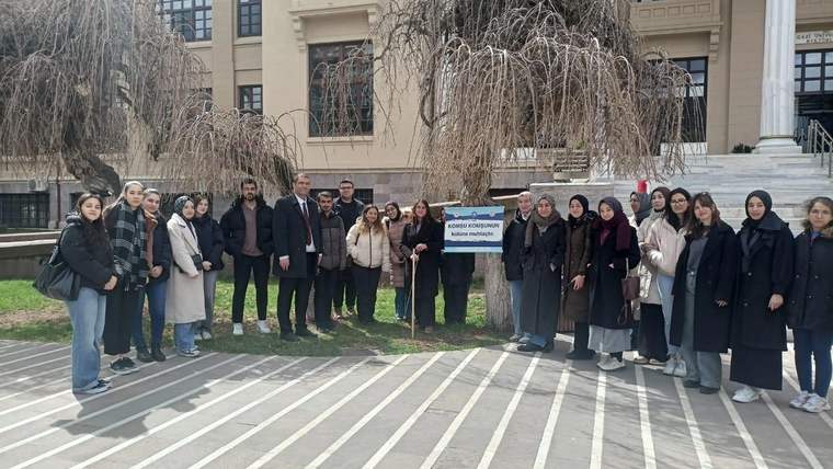 Güneş Saati ve Yerküre Çevresi Hesaplama Etkinliği'nde bir grup insan, tabelanın önünde duruyor.