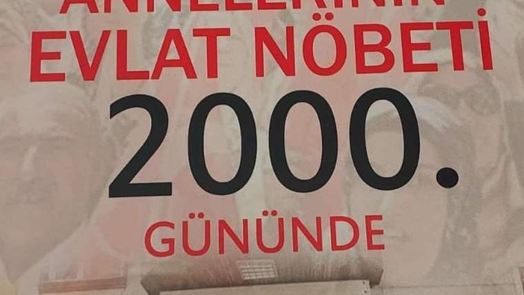 Üzerinde “Annelerin evlat nöbeti 2000 gününde” yazan, kırmızı ve siyah harfli bir pankart.