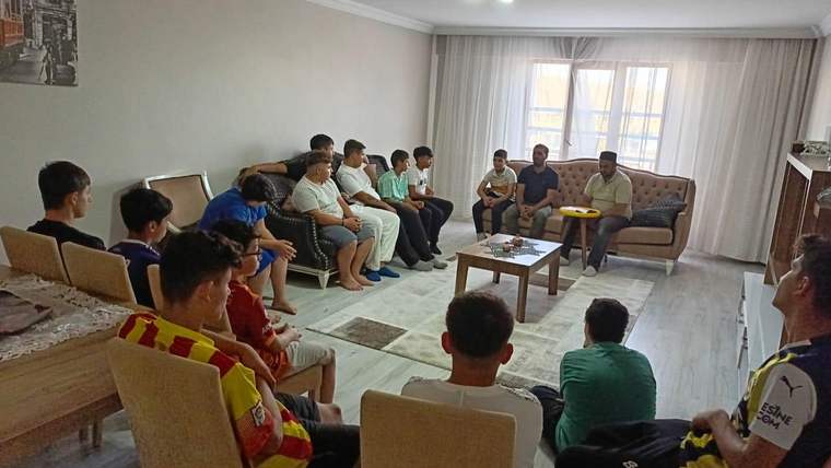 Bir grup çocuk, oturma odasında bir araya gelerek bir etkinlikte yer alıyor.