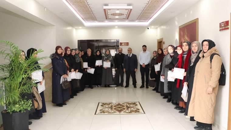 Koridorda bir araya gelen kadın ve erkeklerden oluşan grup, ellerinde belgelerle birlikte duruyor.