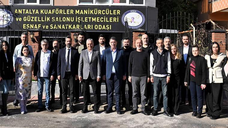 Antalya Kuaförler Manikürcüler ve Güzellik Salonu İşletmecileri Esnaf ve Sanatkârlar Odası tabelası önünde bir grup kişi duruyor.