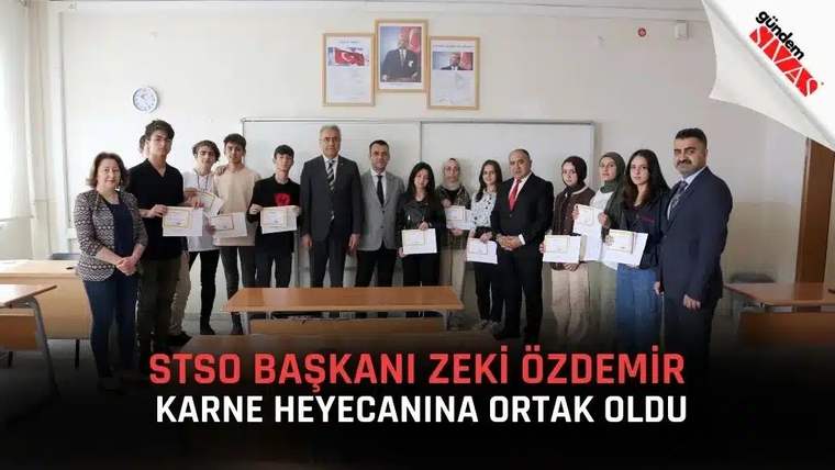 STSO Başkanı Zeki Özdemir, öğrencilere karne belgelerini verirken bir grup öğrenciyle birlikte poz veriyor.