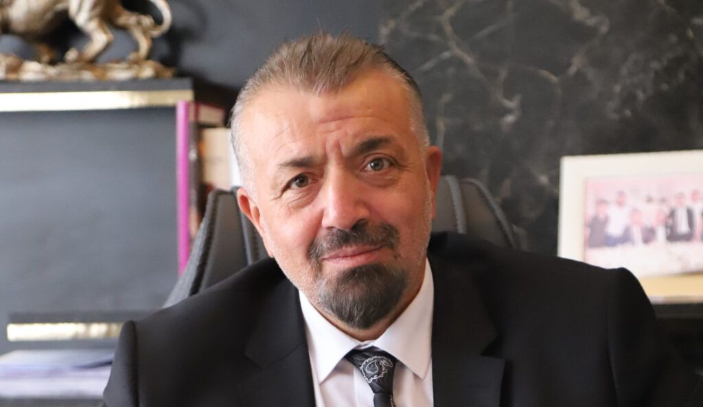 Kırıkkale Baro Başkanı Turan Zeki, ofisinde otururken gülümseyerek poz veriyor.