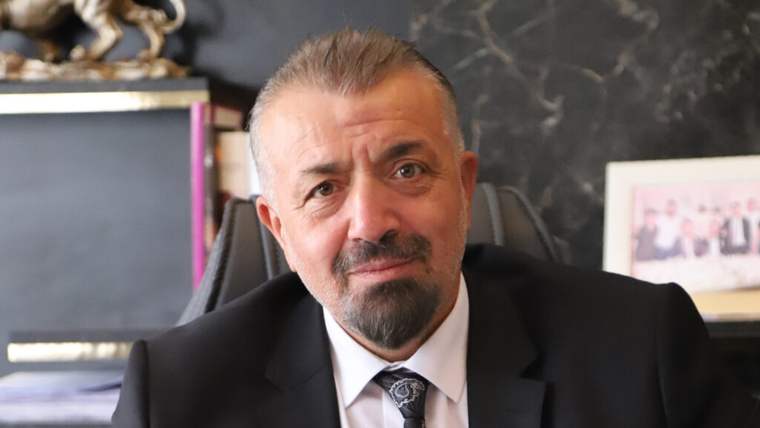 Kırıkkale Baro Başkanı Turan Zeki, ofisinde otururken gülümseyerek poz veriyor.