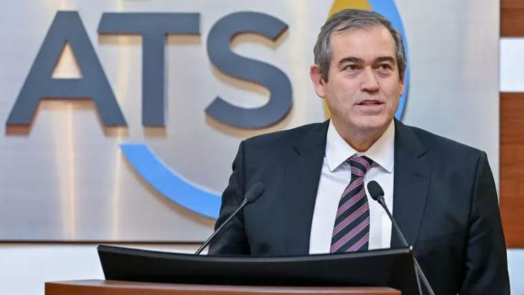 Mikrofonun önünde konuşan bir kişi, arkasında ATSO logosu bulunan bir pano var.