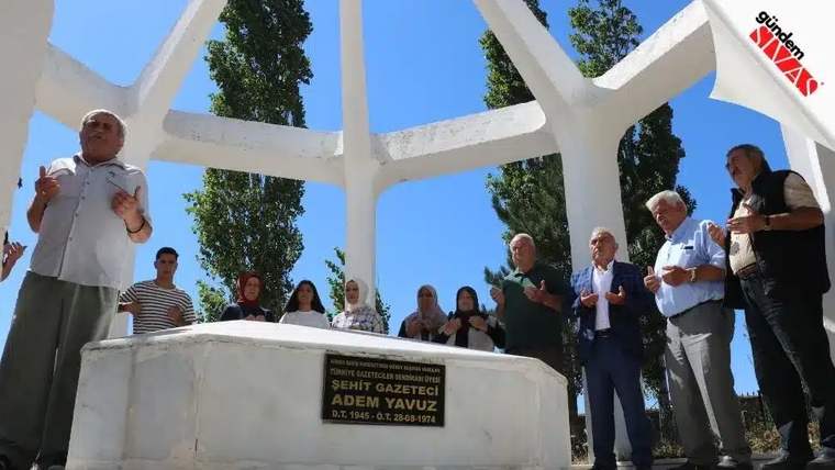 Şehit gazeteci Adem Yavuz'un mezarı başında toplanan kalabalık dua ediyor.