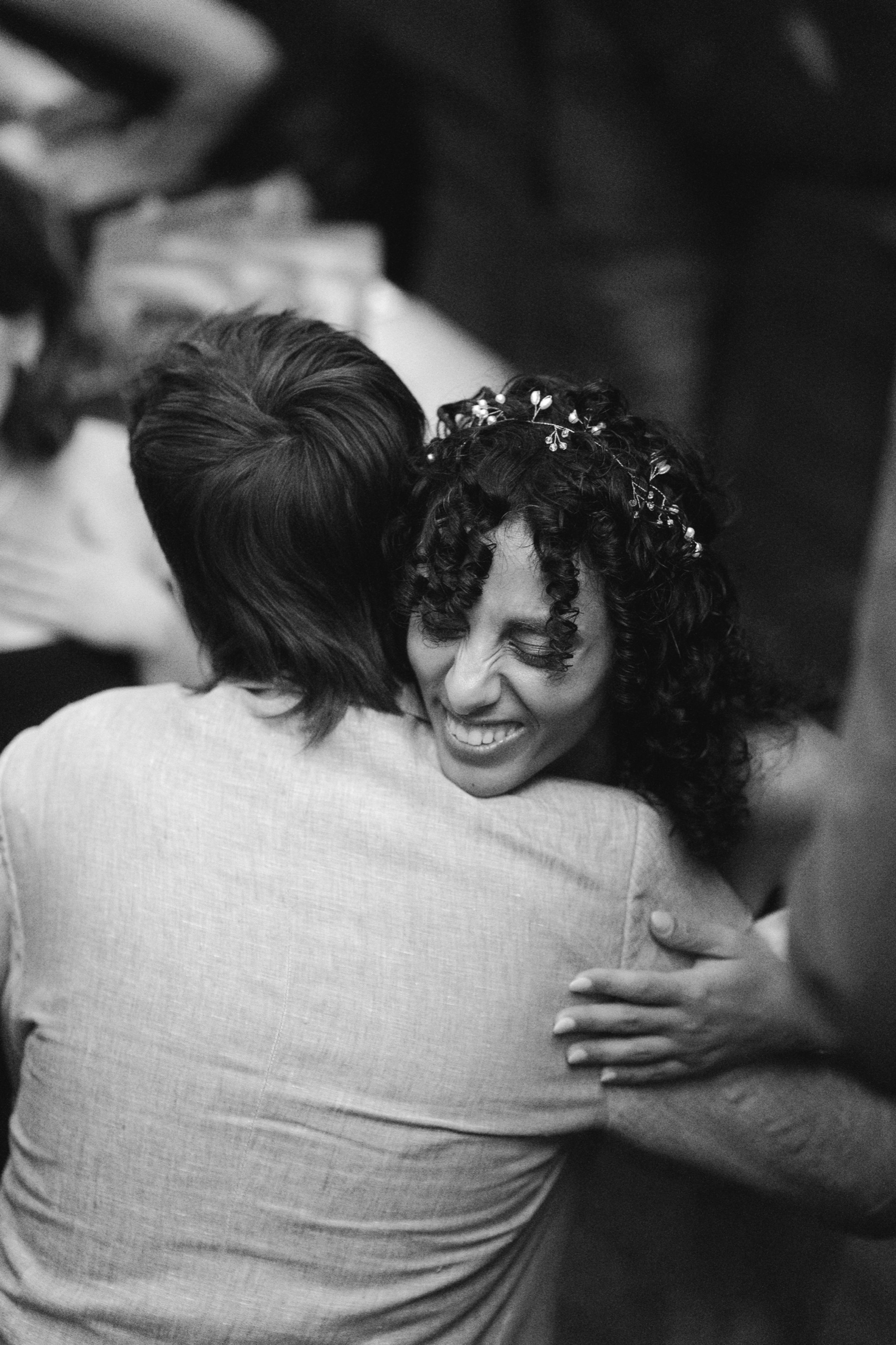 An emotional embrace, one guest wearing a flower crown