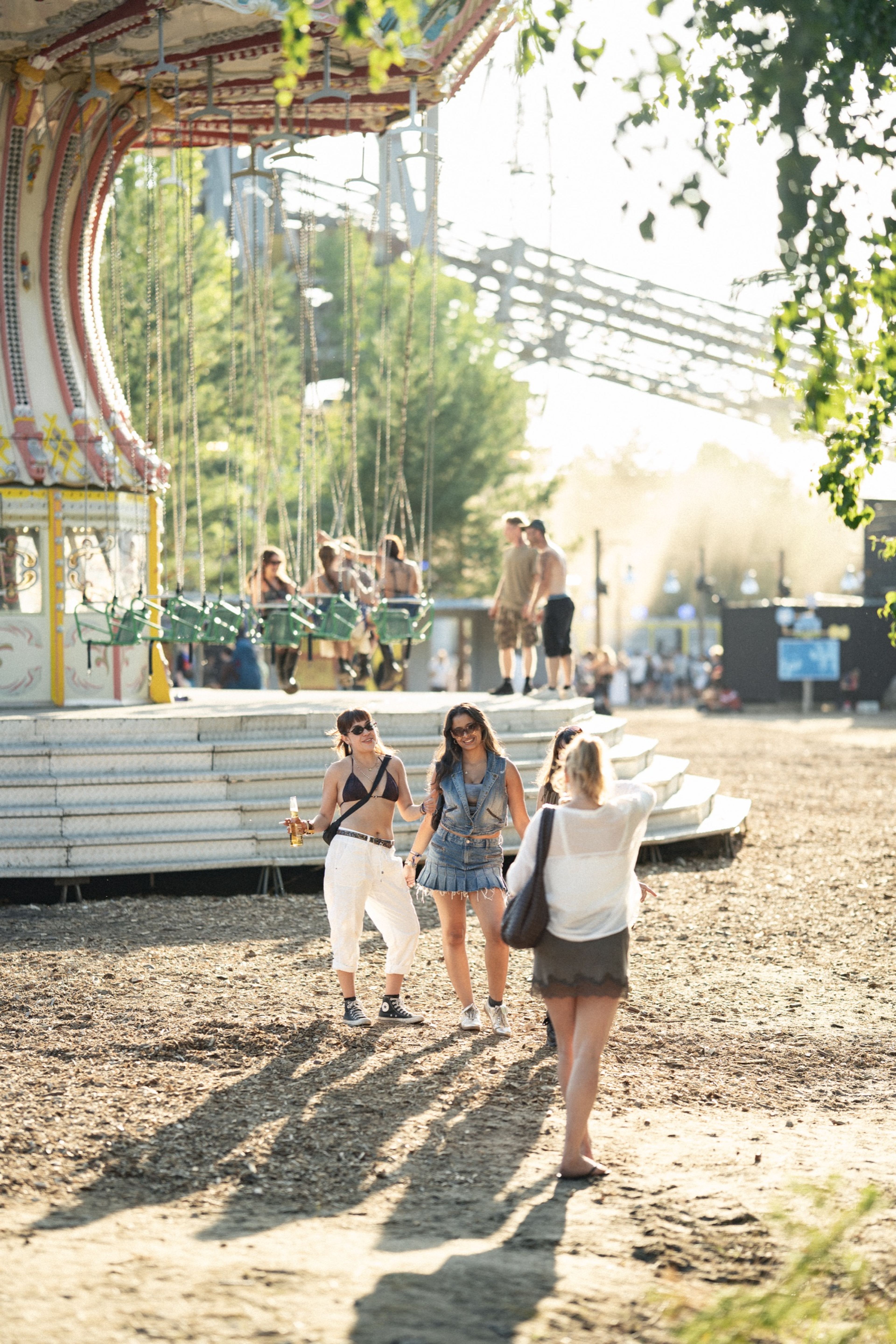 Golden-hour light over the swing carousel and festival grounds by the lake