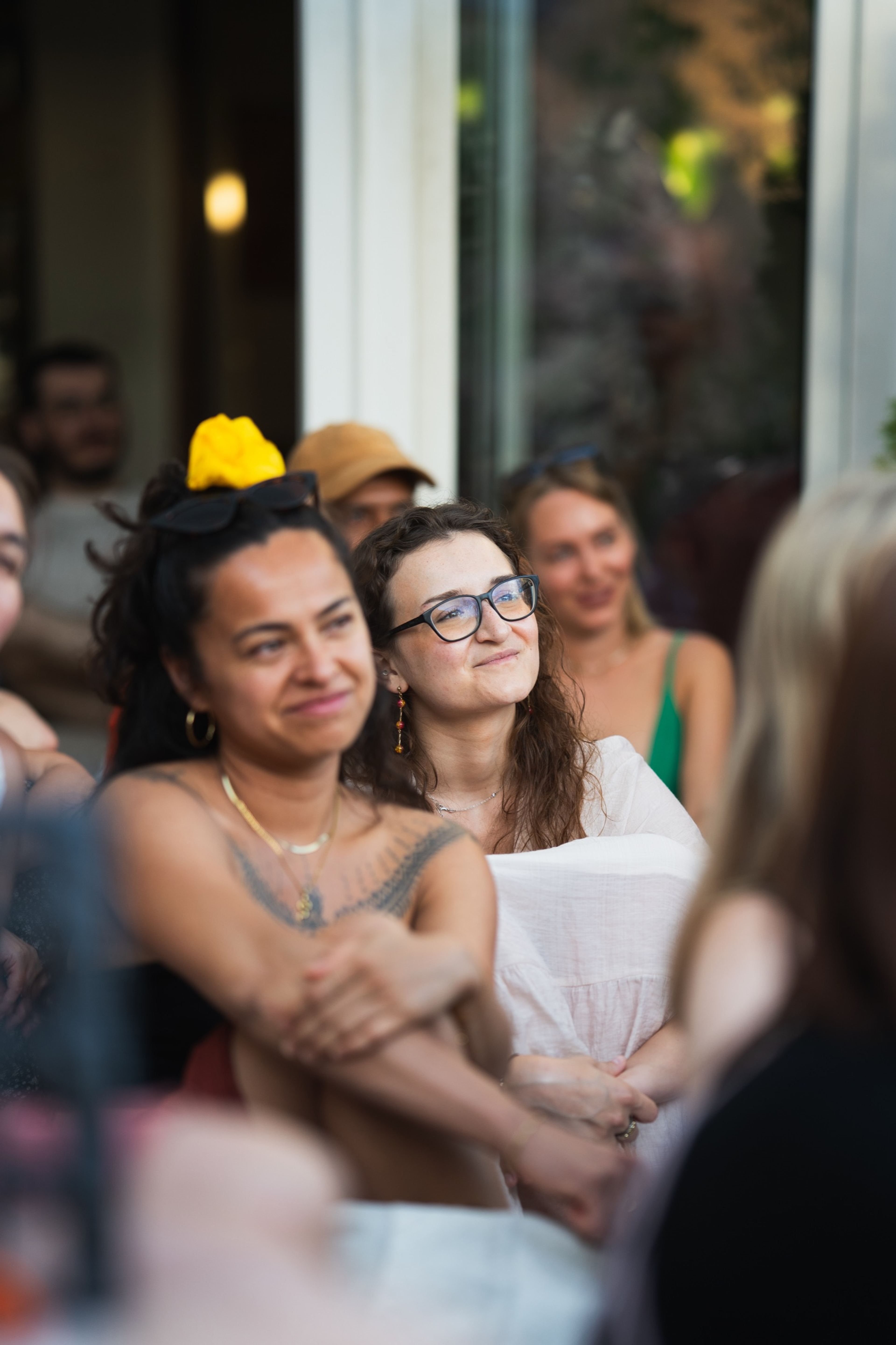 Two friends in the audience smiling as they watch a performance