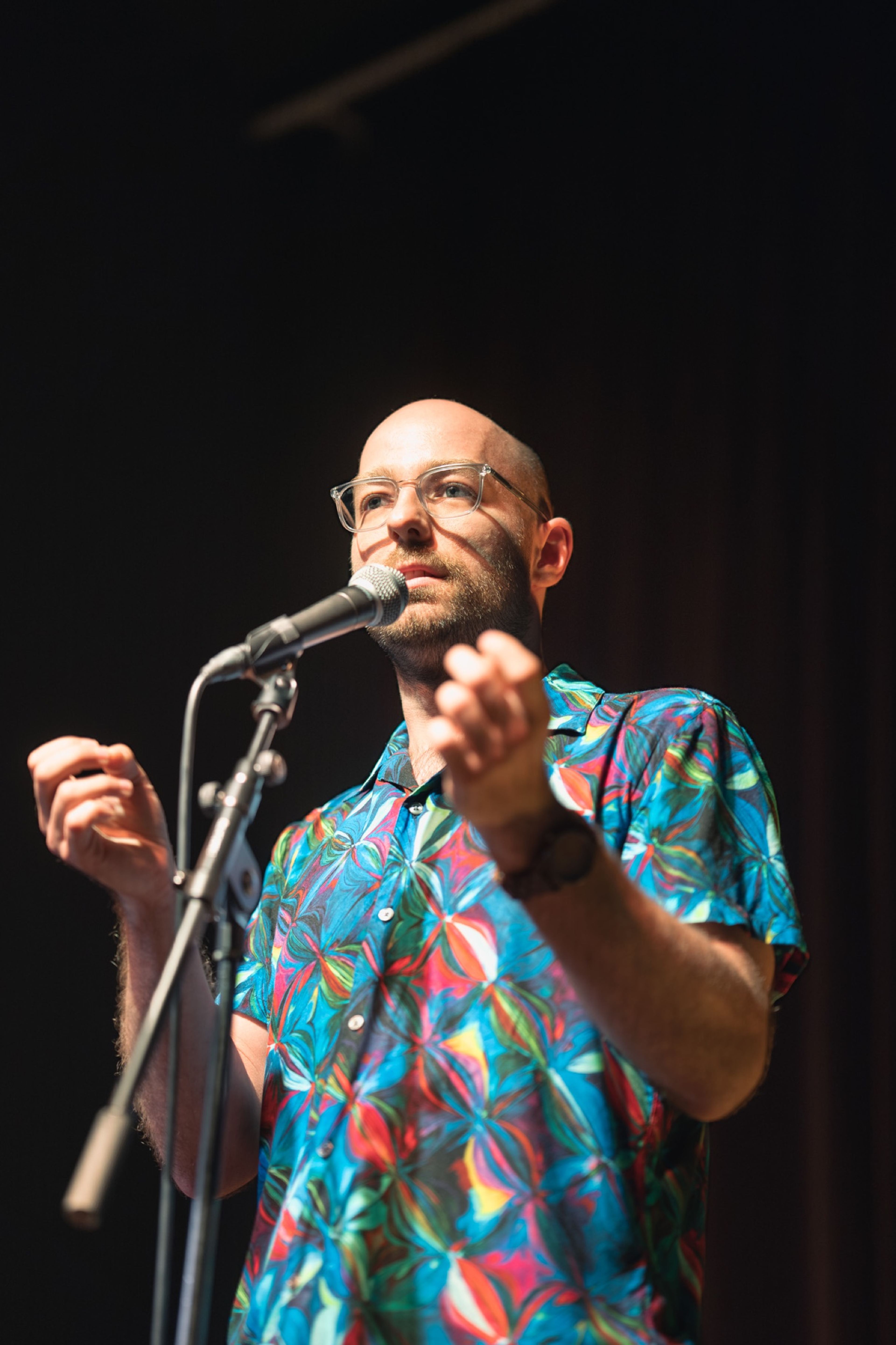 Animated storyteller gesturing as he speaks into the microphone