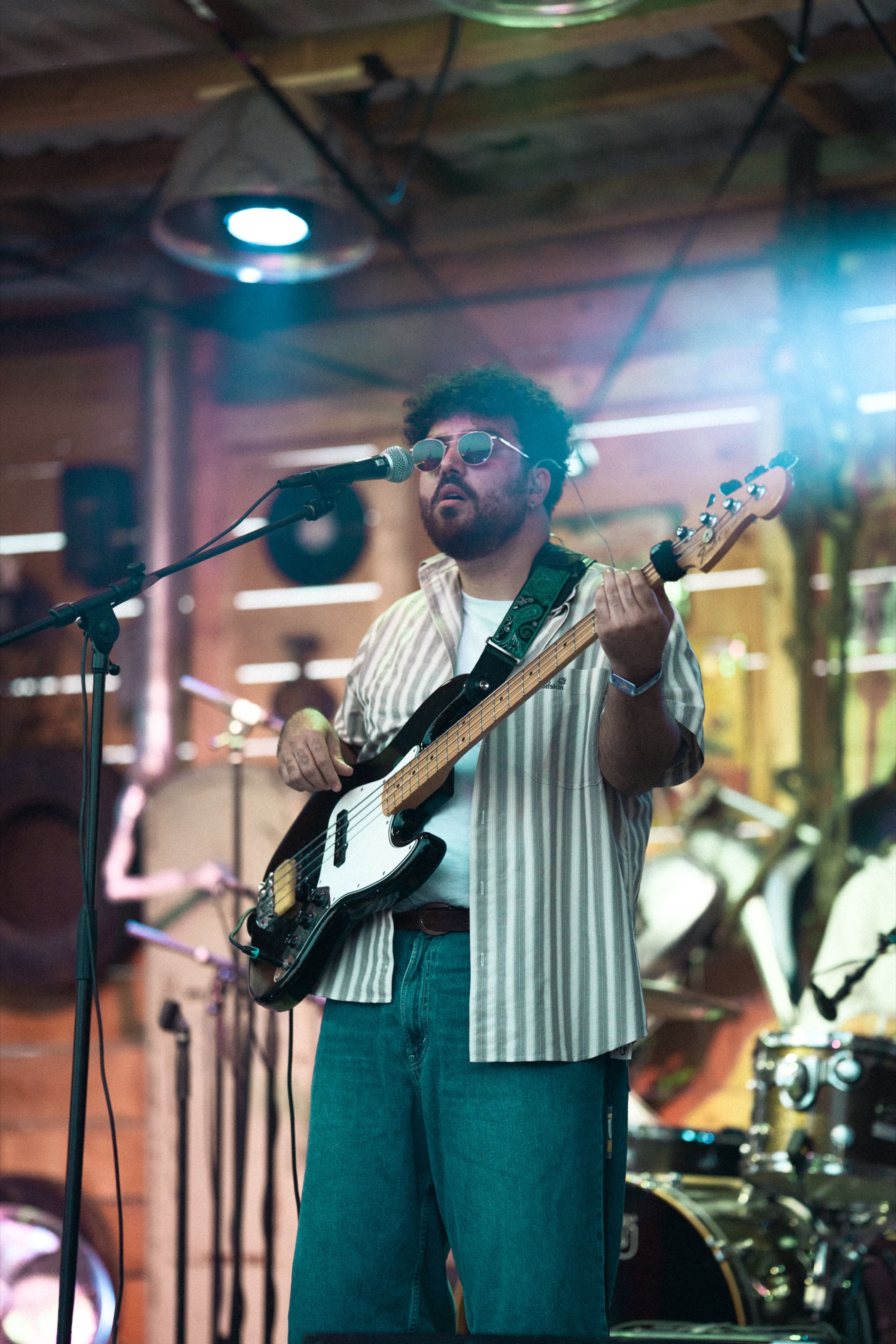 A bassist performing on a warmly lit stage