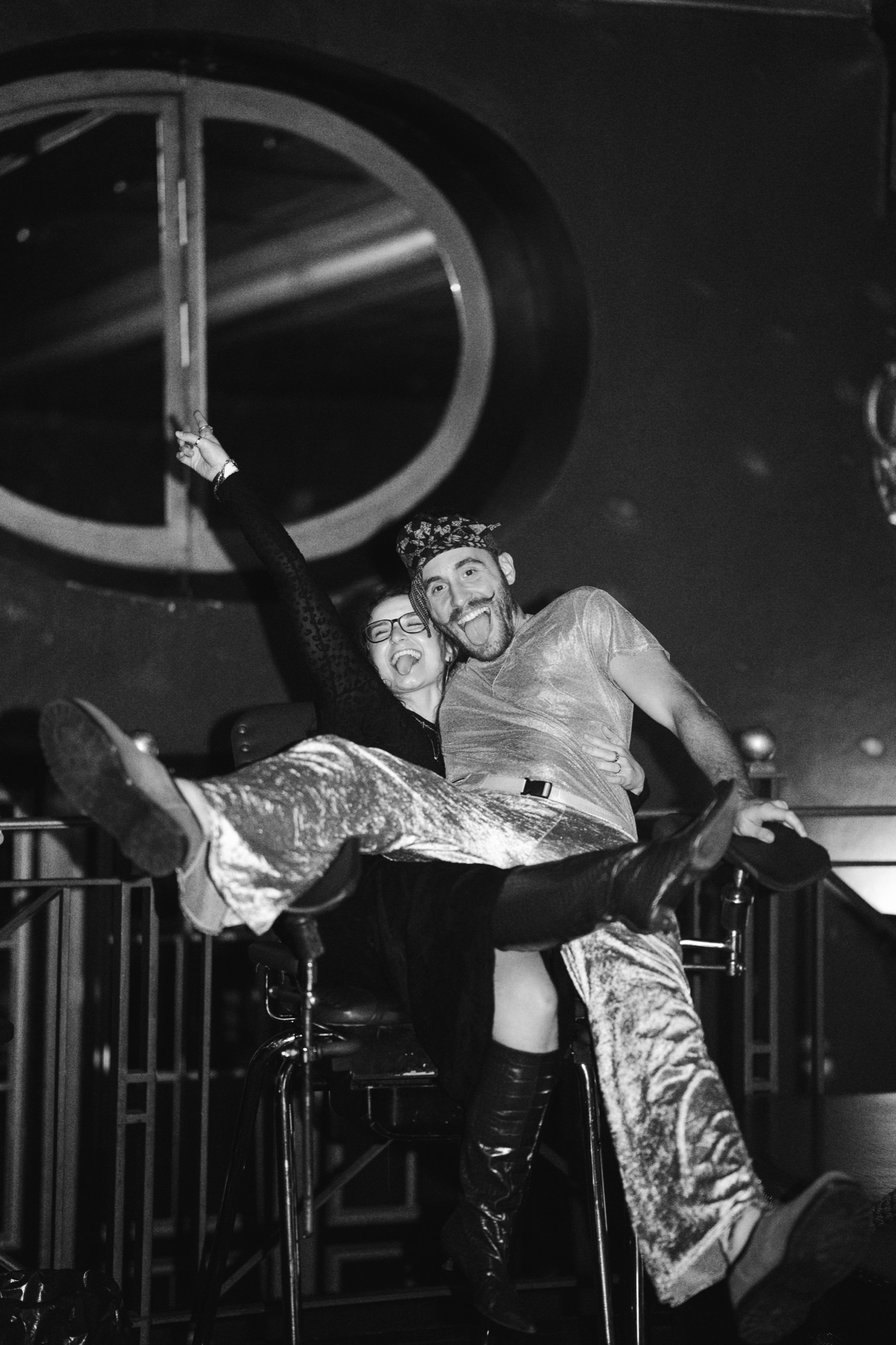 Two guests laughing and clowning around at the end of the night