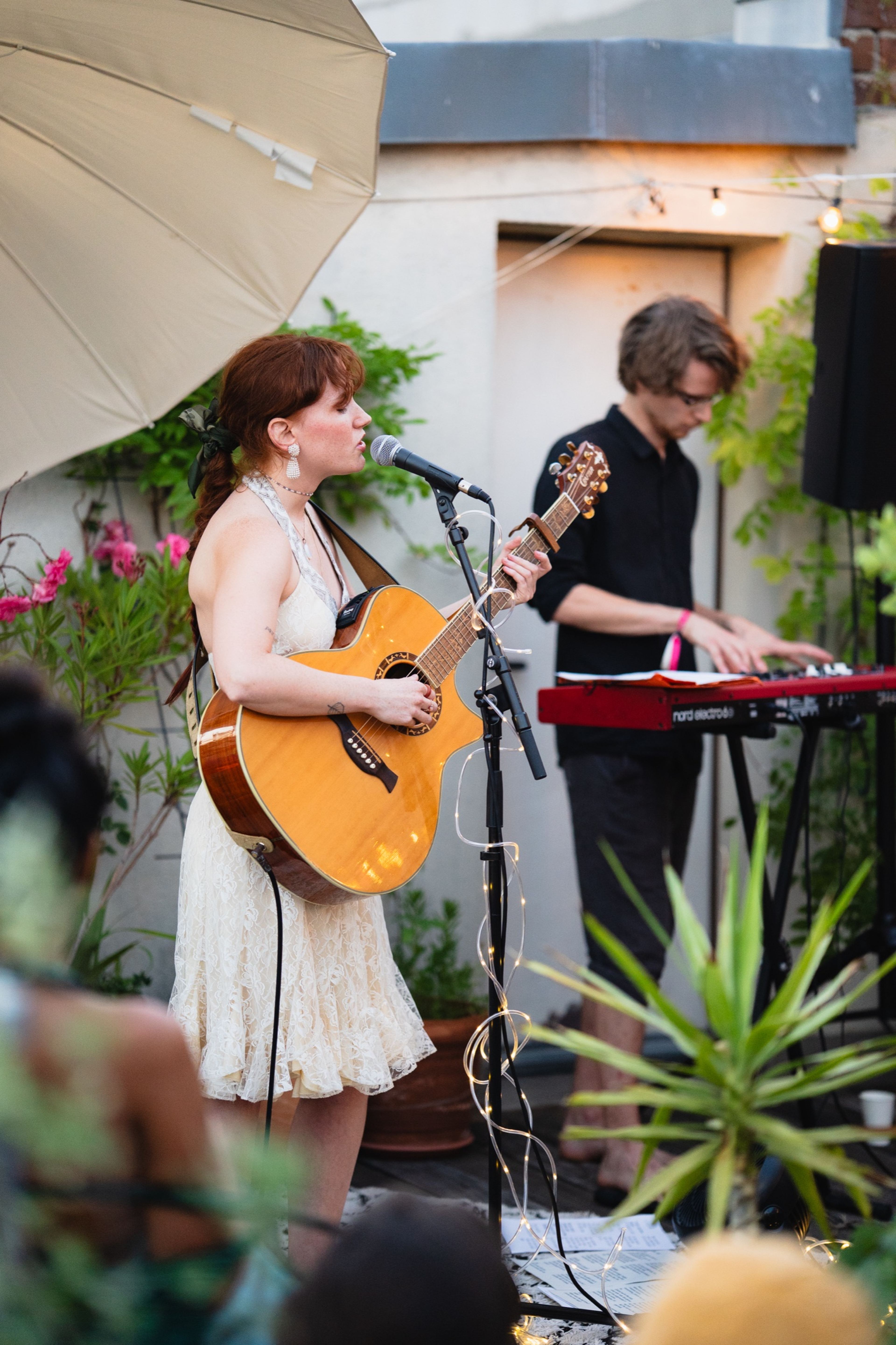 Singer-guitarist and keyboardist performing on the plant-filled rooftop stage