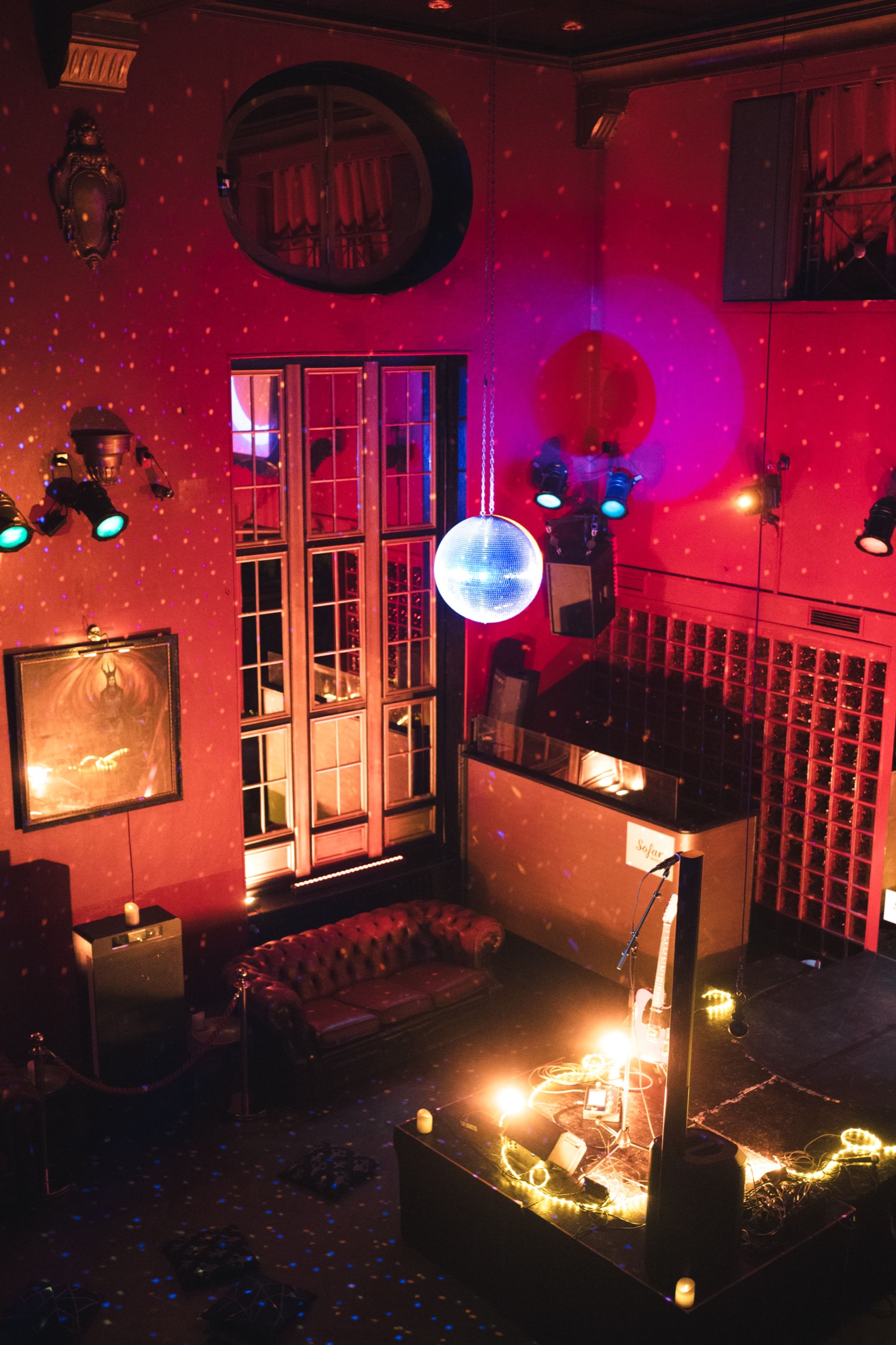 The candle-lit venue set for the show, disco ball glowing red