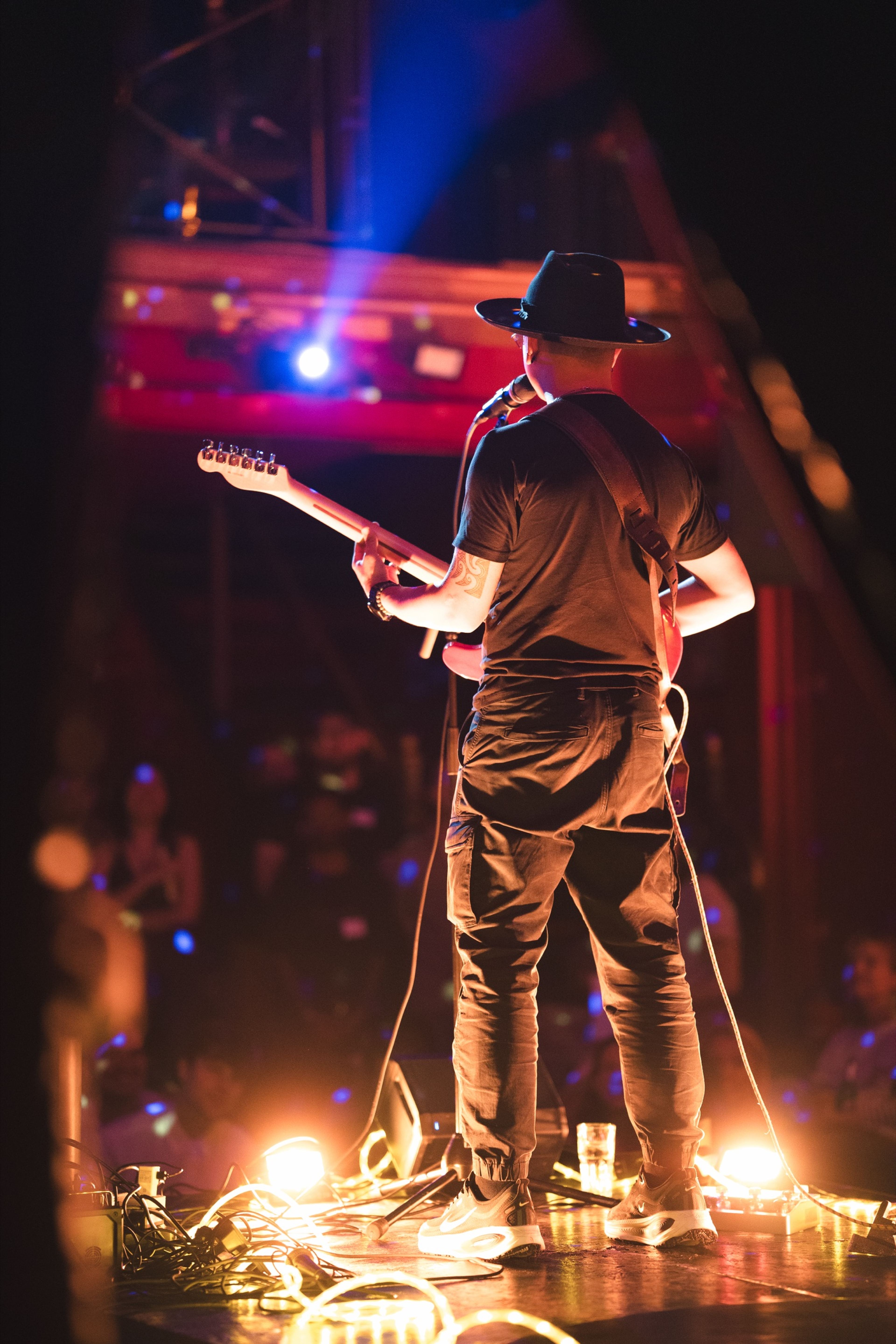 Guitarist silhouetted against blue and red stage light