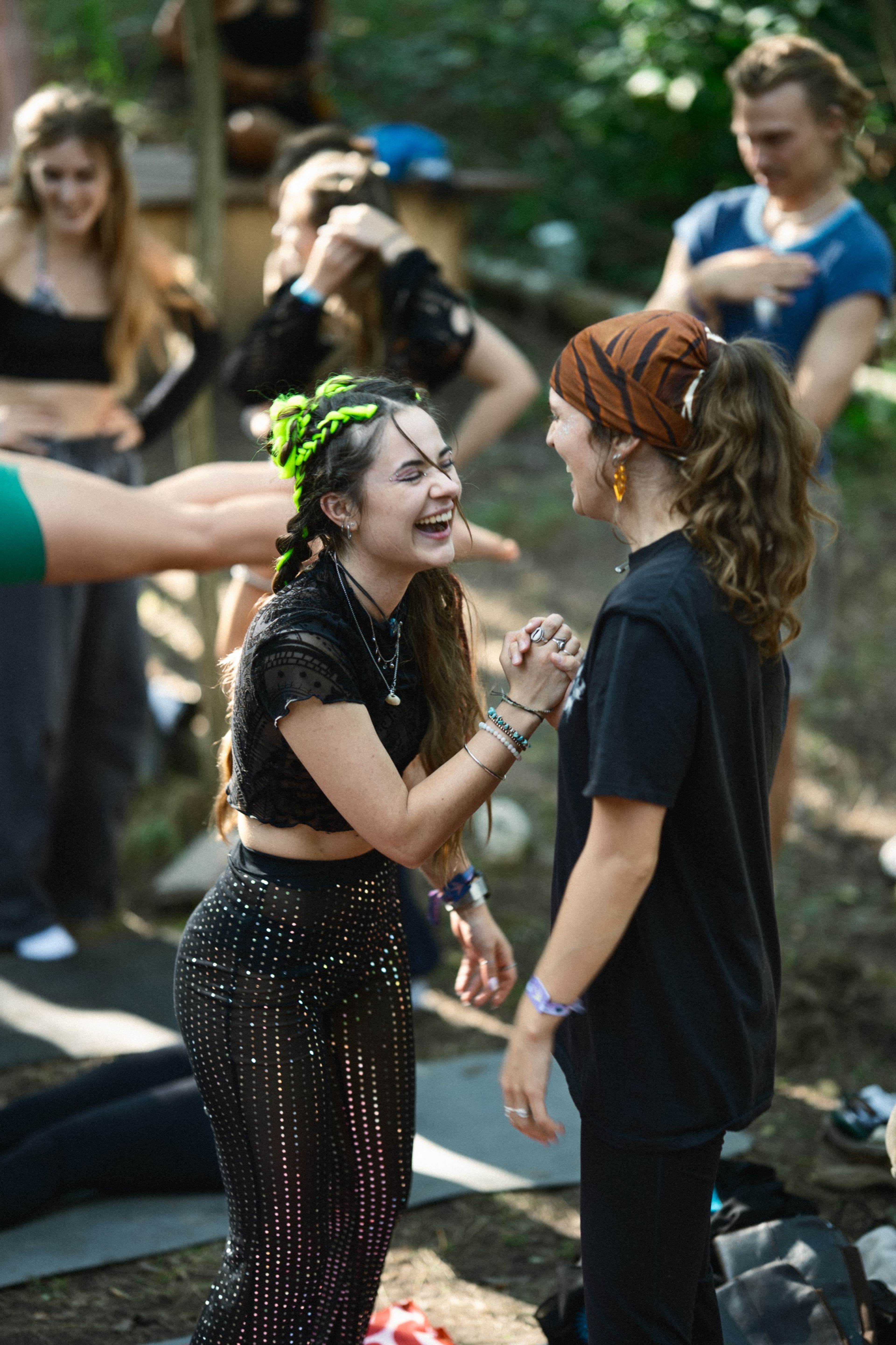 Two friends laughing and dancing together at the festival