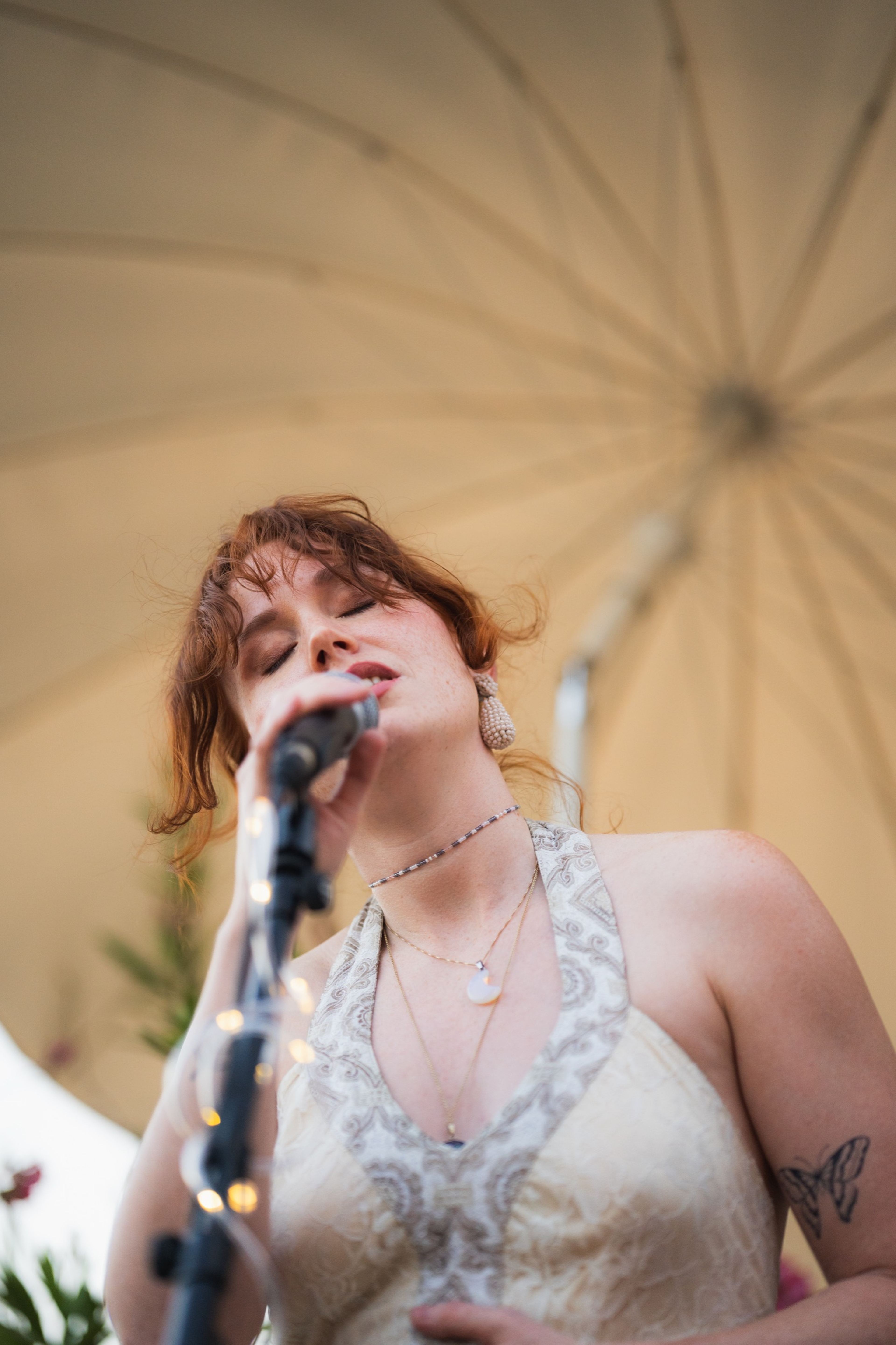 Red-haired vocalist singing with her eyes closed