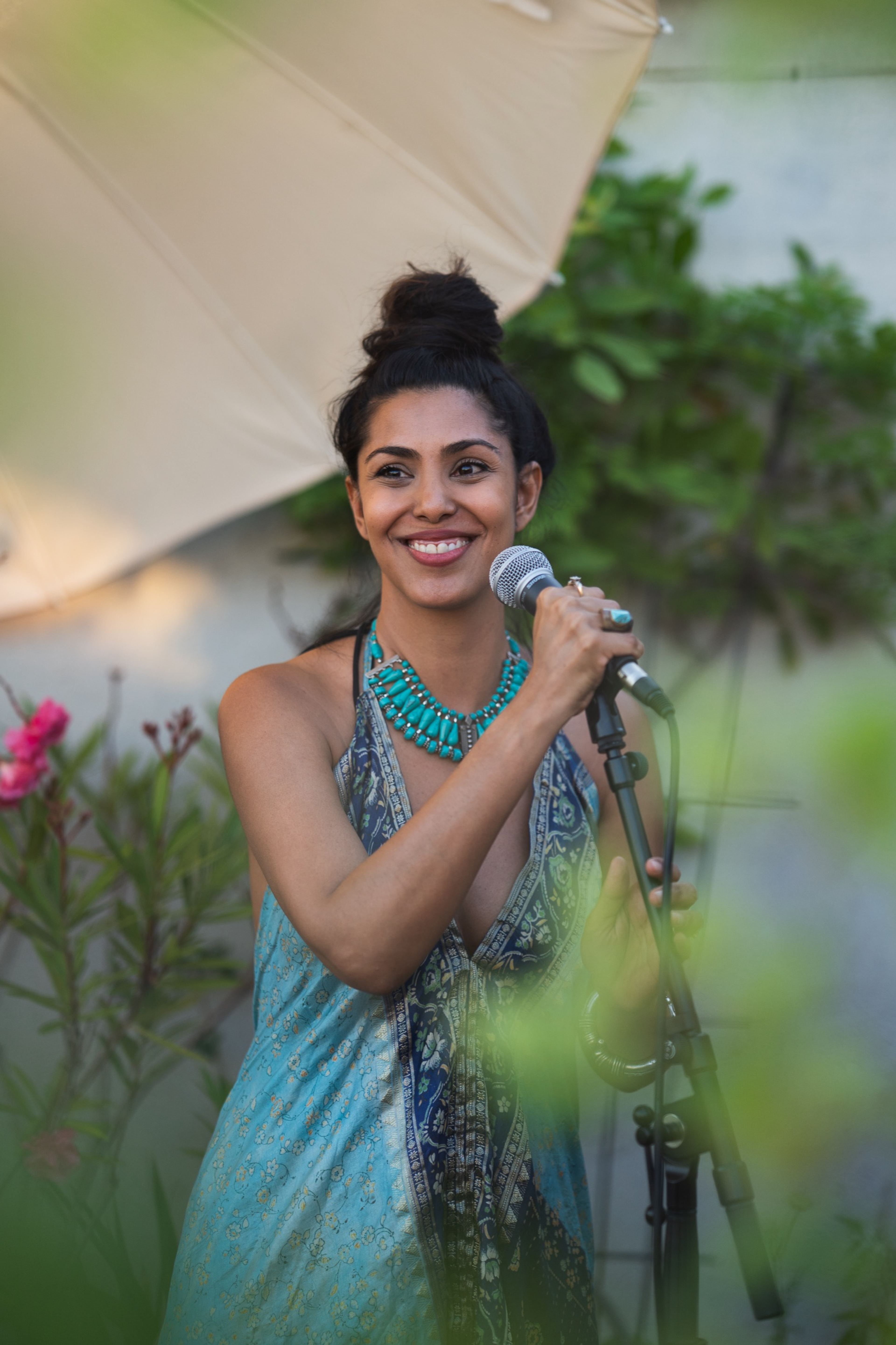 Vocalist in a turquoise necklace smiling during her set