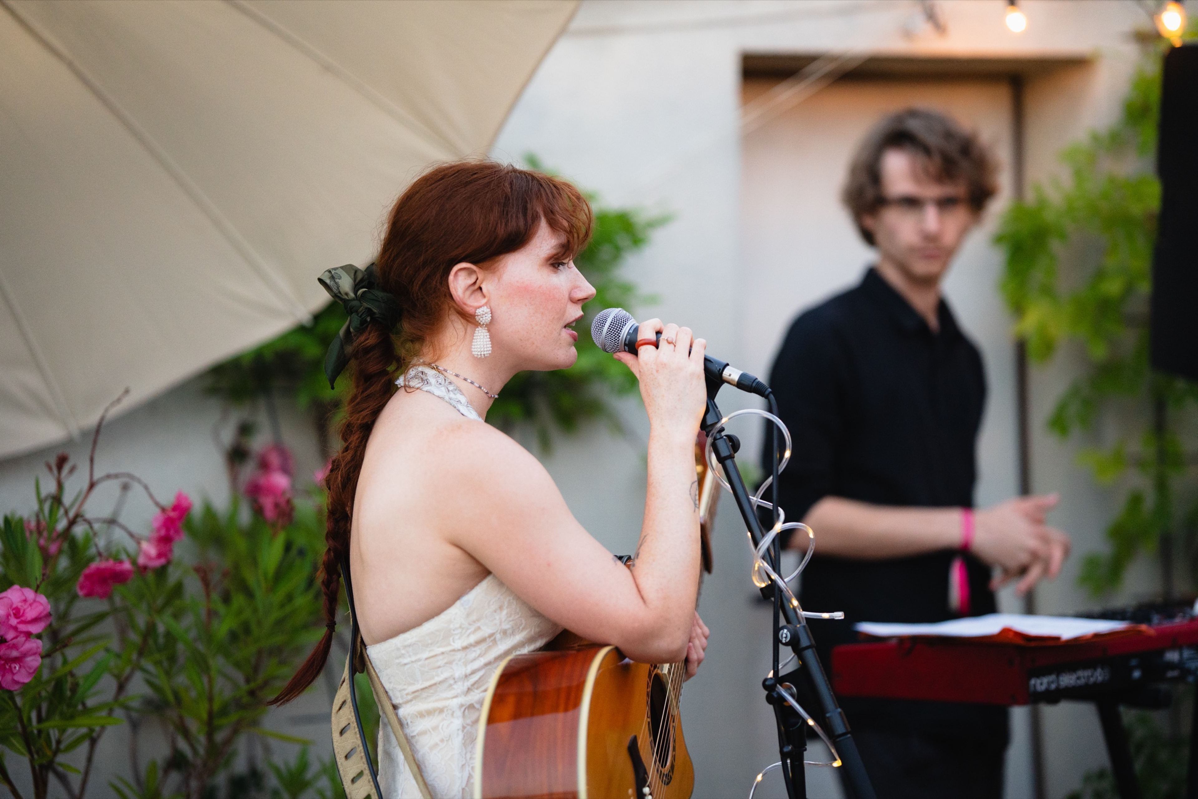 Singer-guitarist and keyboardist performing together on the rooftop stage