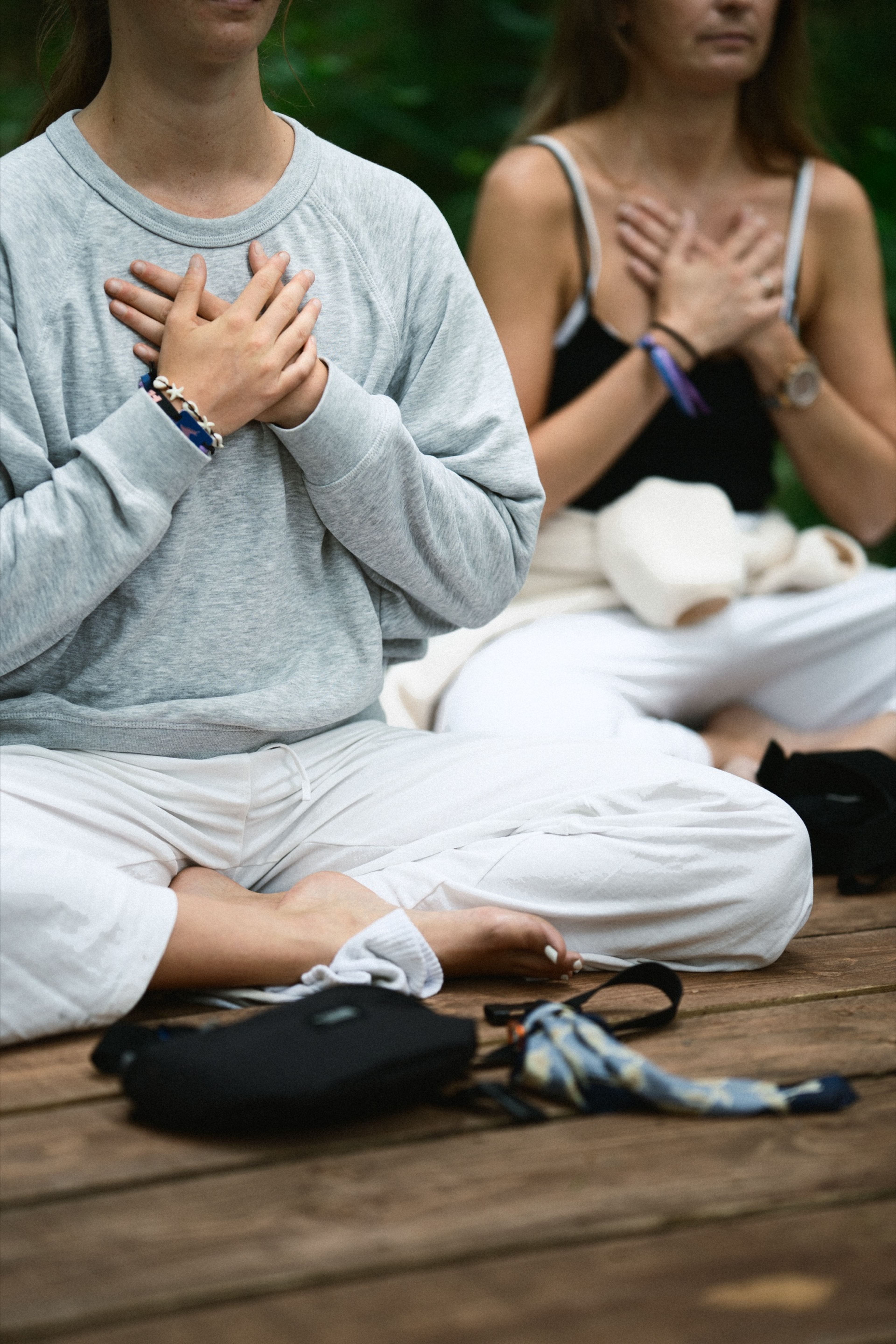 Two people meditating with hands on their hearts, dressed in white