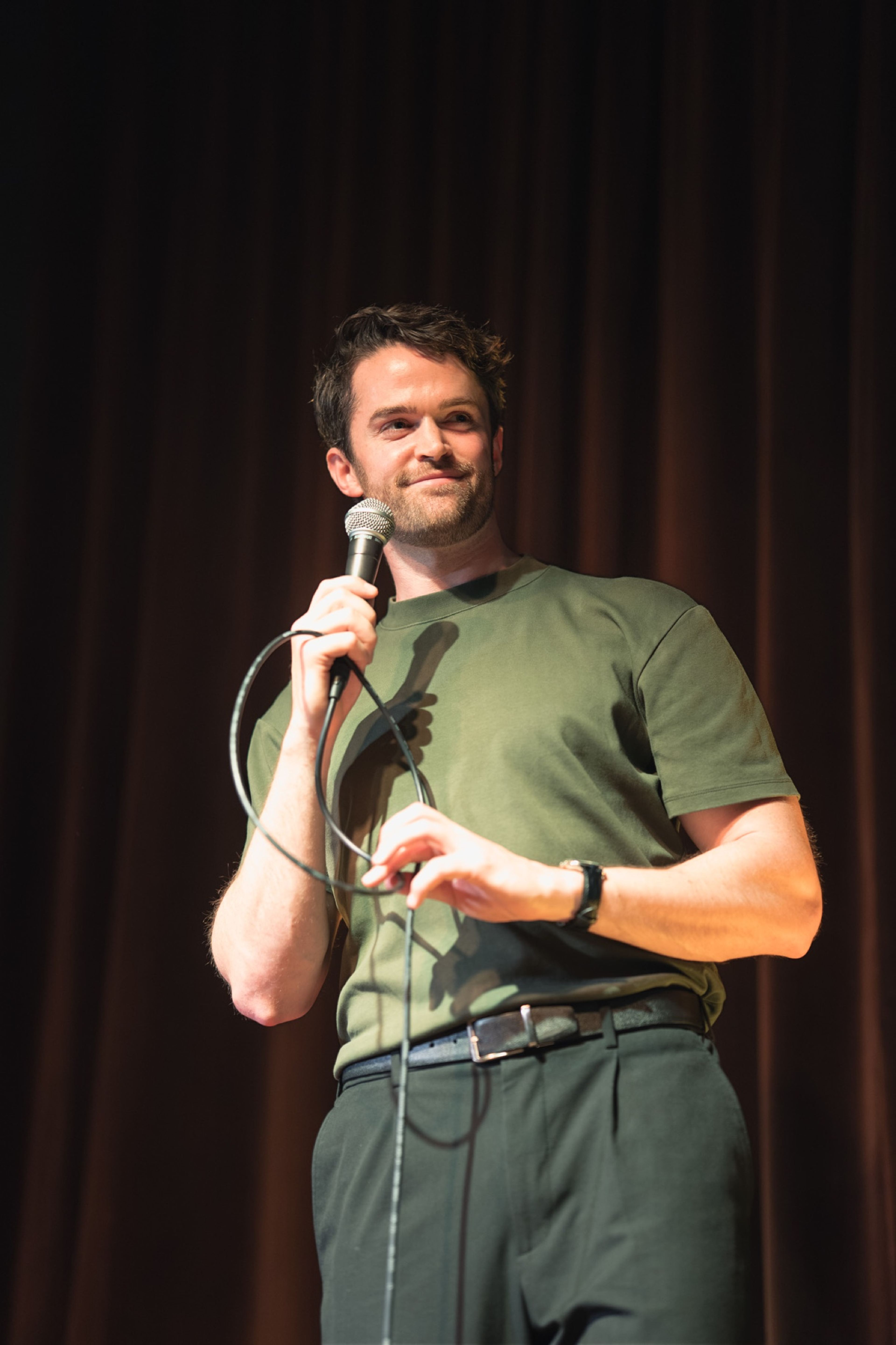 Storyteller mid-story, lit against the dark stage