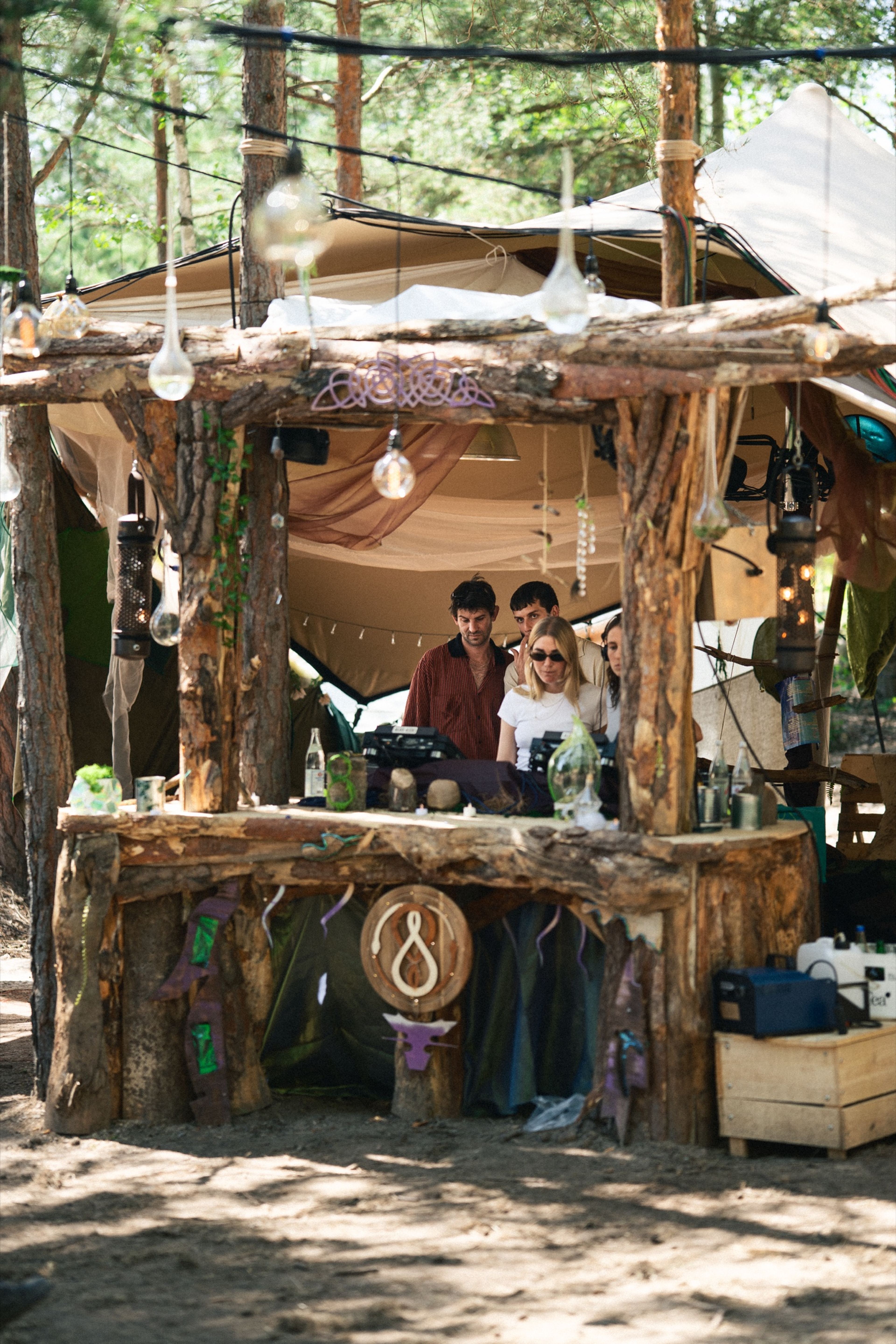 A rustic driftwood DJ booth tucked into the forest