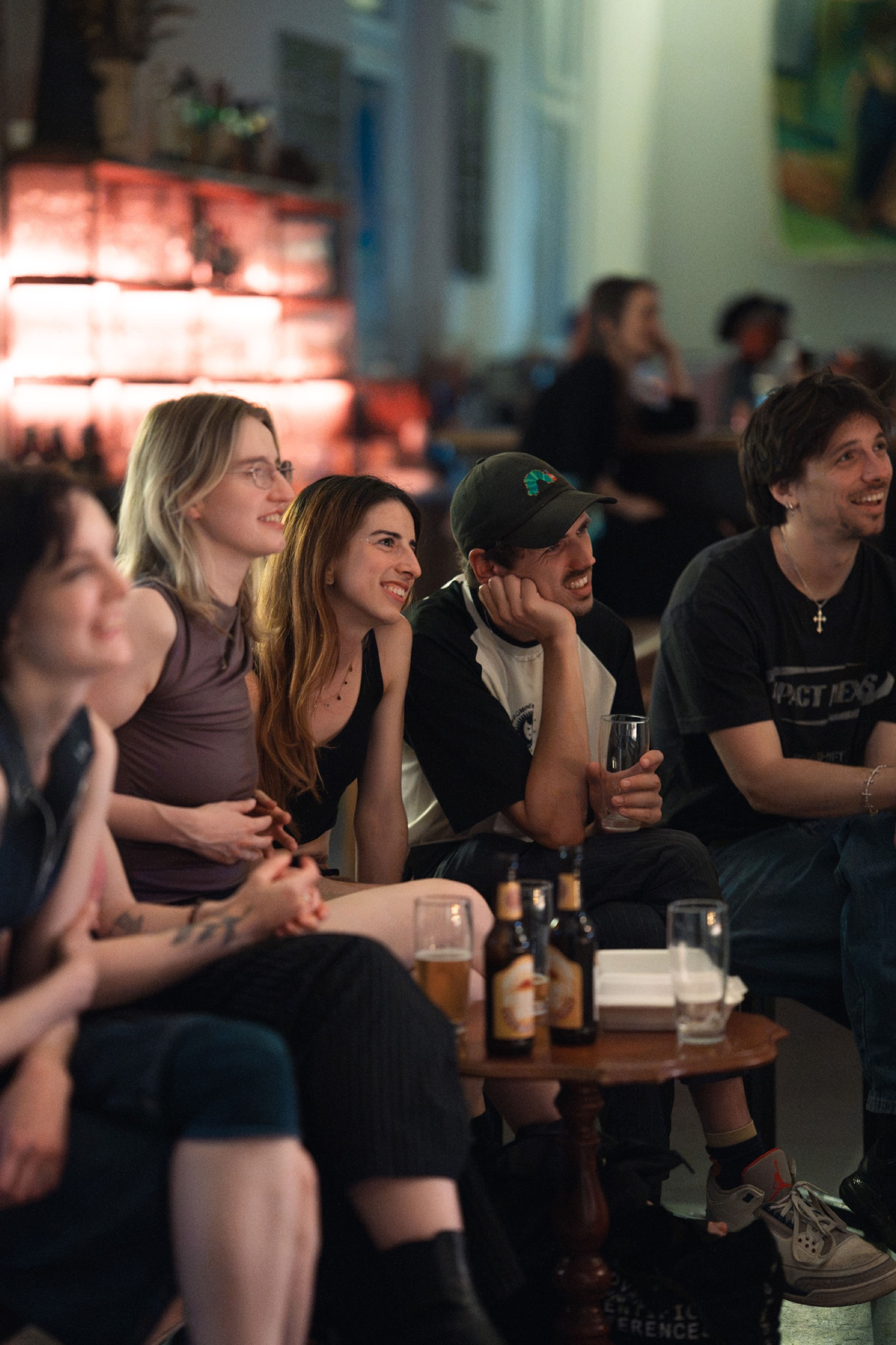 Audience watching intently in the warm, low light