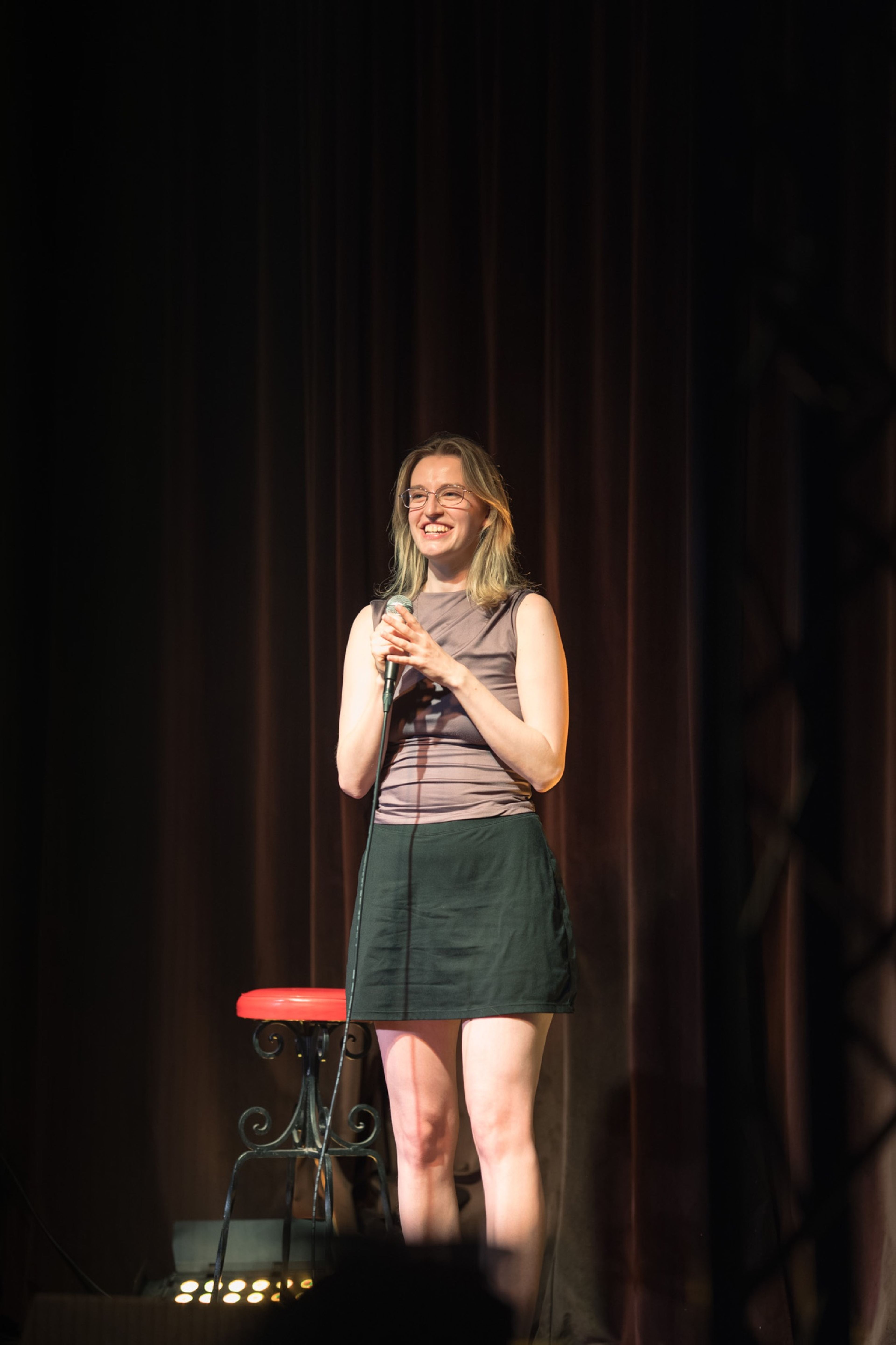 Speaker sharing a story into the microphone on stage