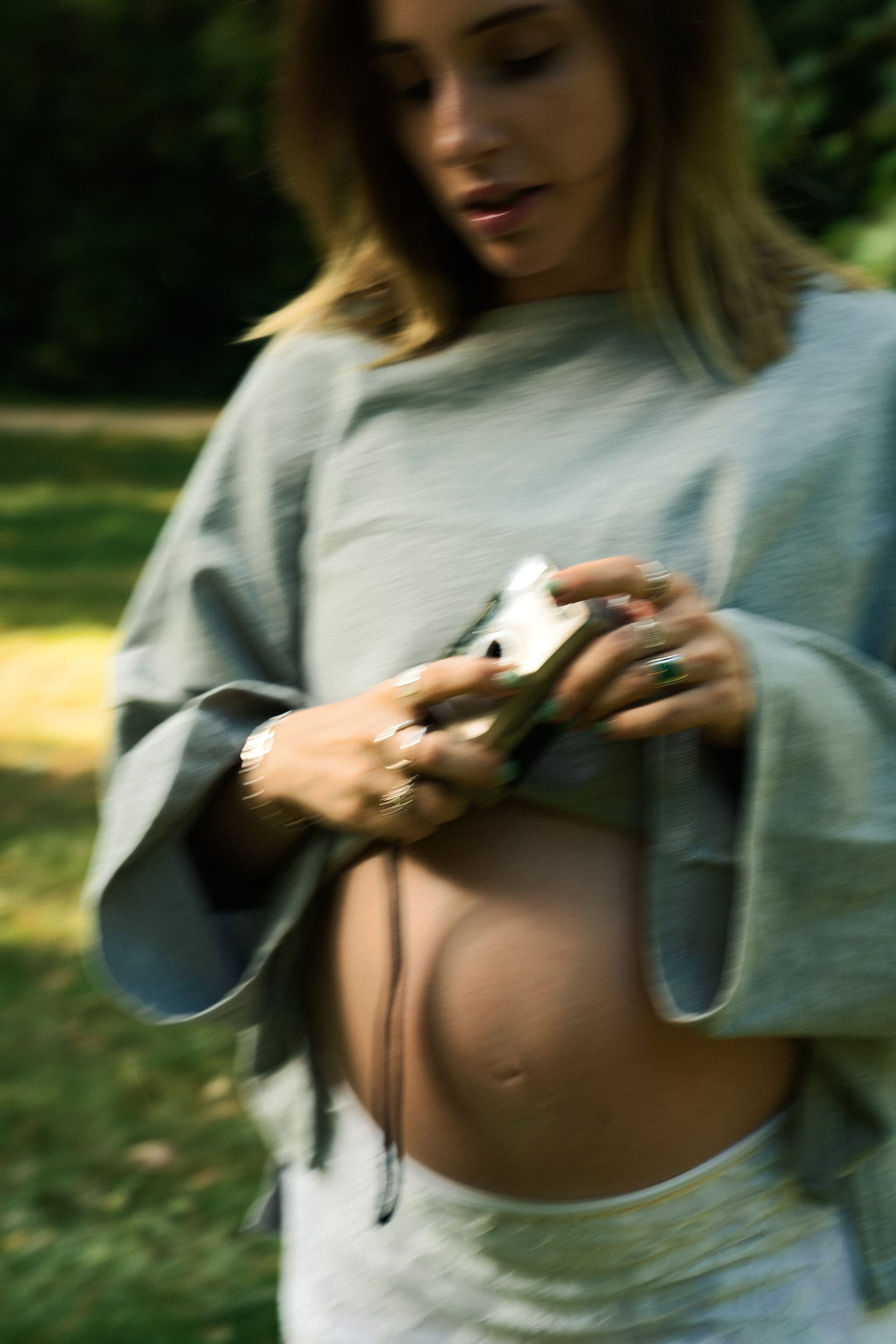 Close, motion-blurred portrait of the expectant mother holding a film camera